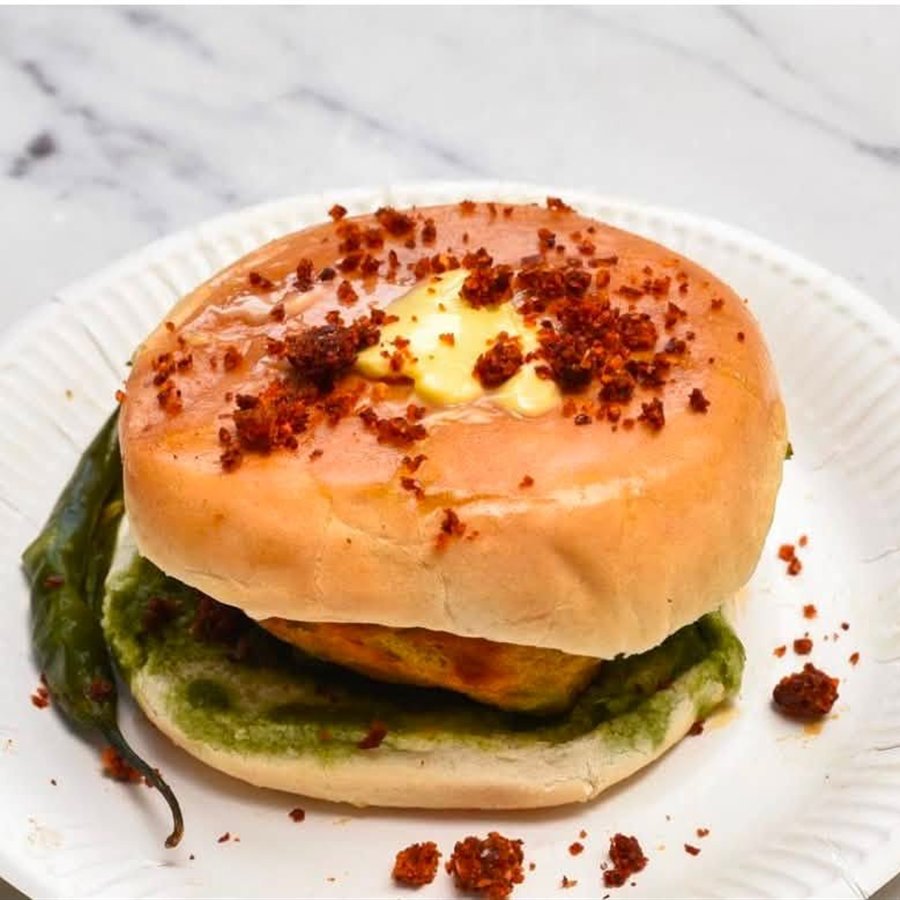 A burger with green chutney and a green chilli