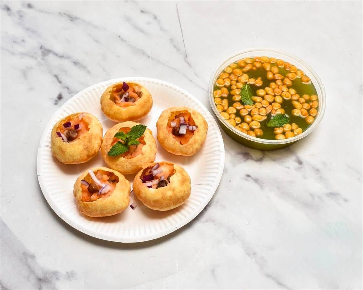 Pani puri on a plate with a tub of pani
